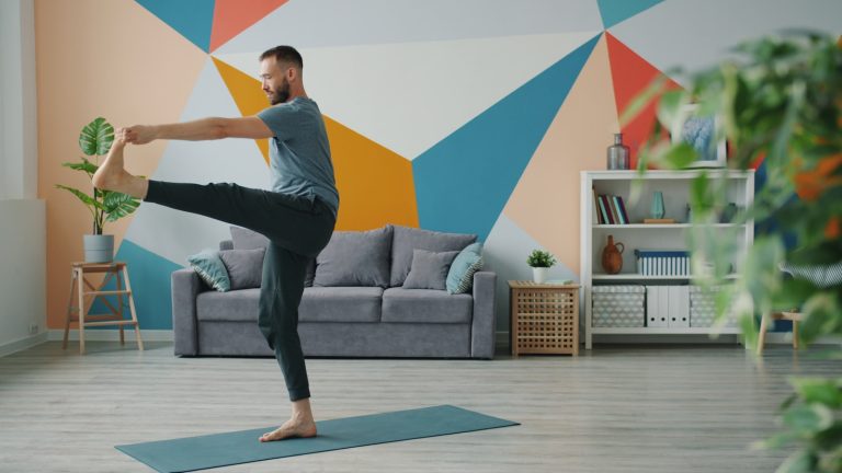Man practicing yoga on a mat in a colorful room.